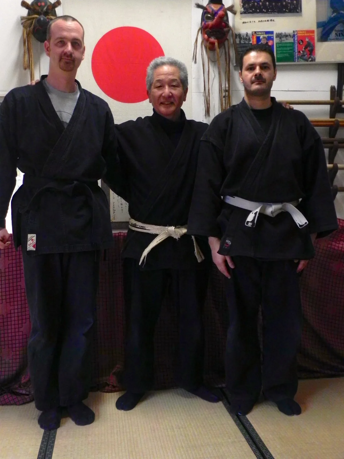 Fabrice Lhermitte, Ishizuka Tetsuji Sensei et Kacem Zoughari devant le drapeau japonais, au dojo au Japon